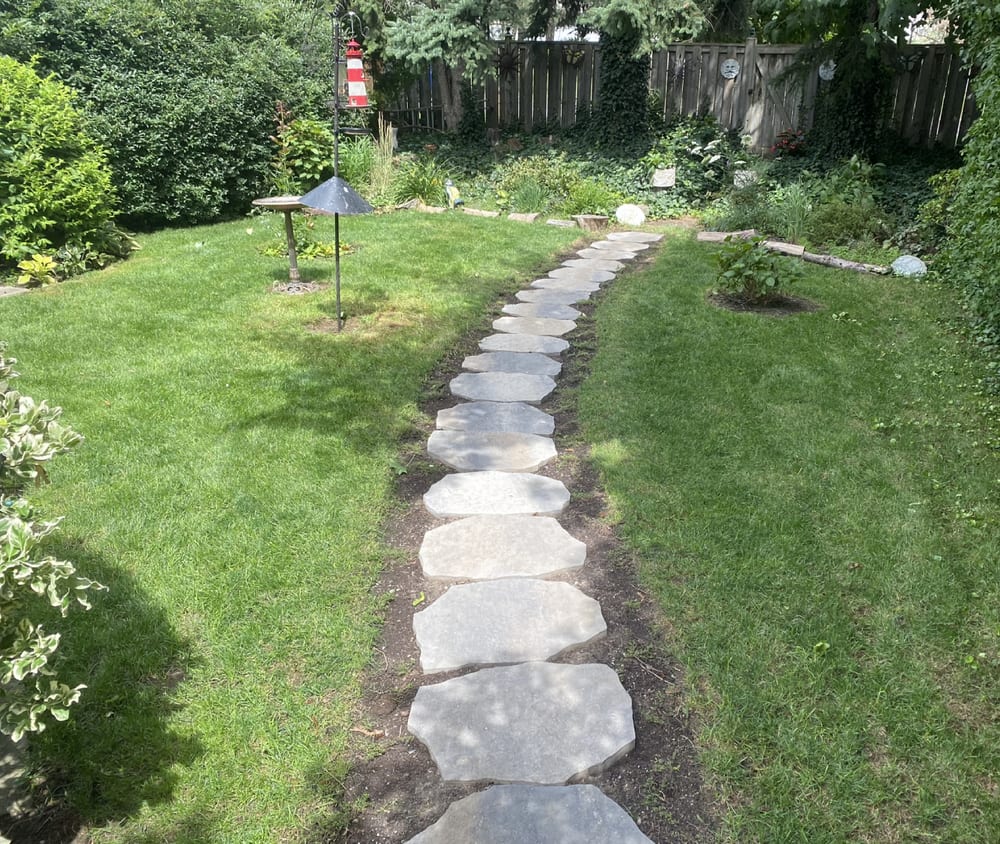 Backyard with a stone path and cut lawn